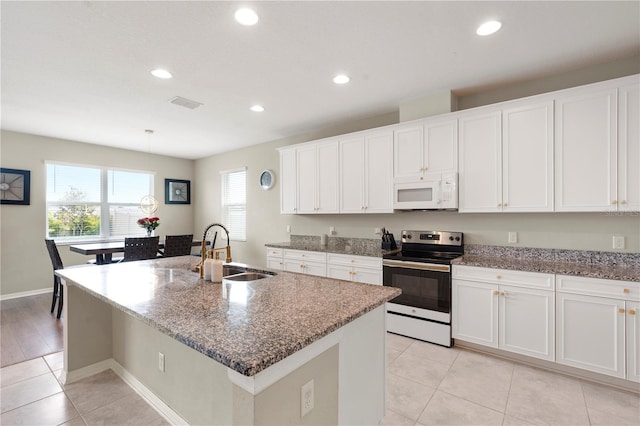 4917 Eagle Rock Dr, Wimauma, FL 33598 - kitchen with stainless steel electric range, white microwave, a sink, recessed lighting, and dark stone counters