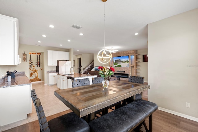 4917 Eagle Rock Dr, Wimauma, FL 33598 - dining area featuring recessed lighting, baseboards, a chandelier, light wood-type flooring, and stairs