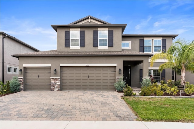4917 Eagle Rock Dr, Wimauma, FL 33598 - view of front of house with stucco siding, decorative driveway, and a garage
