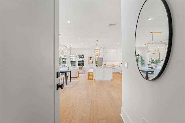 2200 N Glenwood Dr, Tampa, FL 33602 - corridor featuring a chandelier, recessed lighting, light wood finished floors, a sink, and baseboards