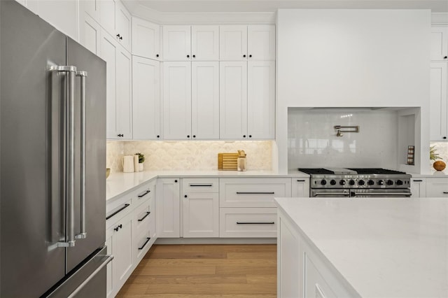 2200 N Glenwood Dr, Tampa, FL 33602 - kitchen featuring high end appliances, light countertops, white cabinetry, and light wood-type flooring