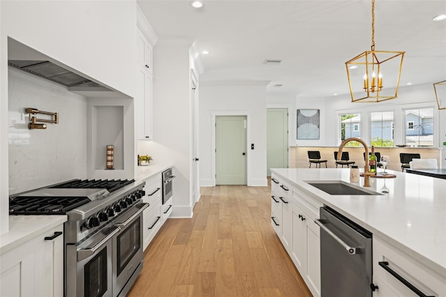 2200 N Glenwood Dr, Tampa, FL 33602 - kitchen featuring a sink, stainless steel appliances, recessed lighting, white cabinetry, and hanging light fixtures