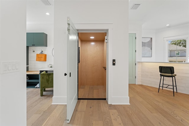 2200 N Glenwood Dr, Tampa, FL 33602 - corridor with light wood-type flooring, ornamental molding, recessed lighting, elevator, and baseboards