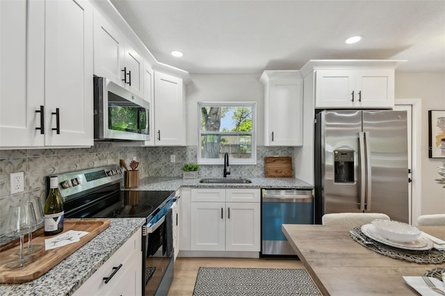 5624 62nd St N, Saint Petersburg, FL 33709 - kitchen featuring stainless steel appliances, a sink, white cabinets, backsplash, and recessed lighting