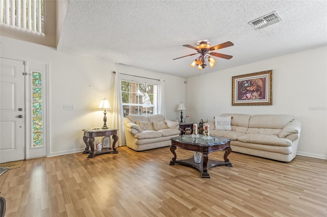 10311 Frog Pond Dr, Riverview, FL 33569 - living room featuring light wood-style flooring, a ceiling fan, a textured ceiling, and baseboards