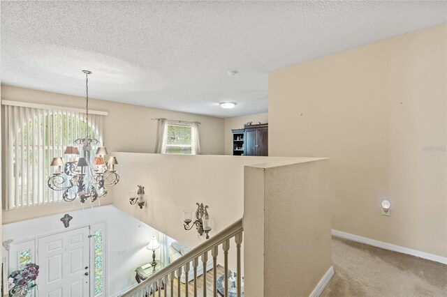 10311 Frog Pond Dr, Riverview, FL 33569 - stairway featuring a chandelier, carpet floors, baseboards, and a textured ceiling