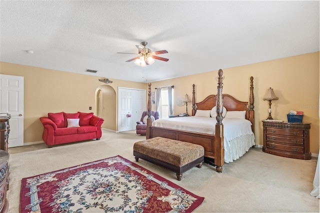 10311 Frog Pond Dr, Riverview, FL 33569 - bedroom with carpet, arched walkways, a ceiling fan, baseboards, and a textured ceiling