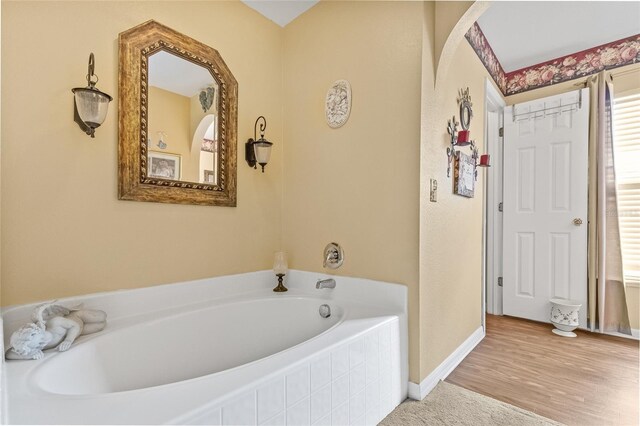 10311 Frog Pond Dr, Riverview, FL 33569 - bathroom featuring a bath, baseboards, and wood finished floors