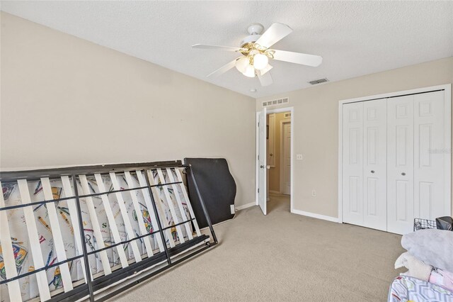10311 Frog Pond Dr, Riverview, FL 33569 - bedroom featuring carpet flooring, baseboards, ceiling fan, a closet, and a textured ceiling