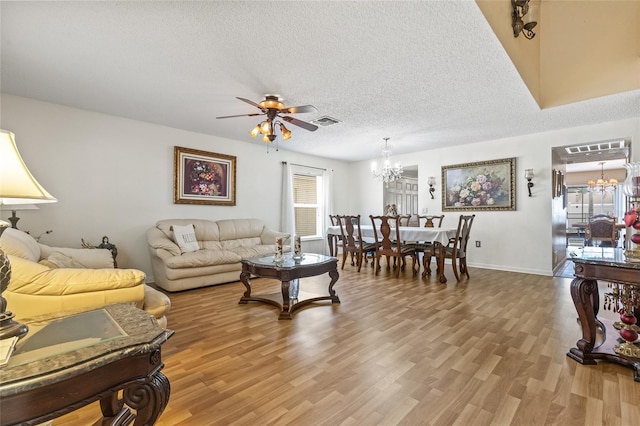 10311 Frog Pond Dr, Riverview, FL 33569 - living room with a chandelier, ceiling fan, a textured ceiling, light wood-style floors, and baseboards