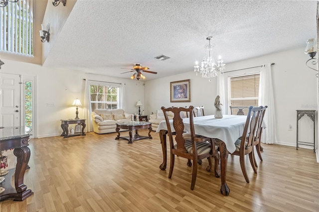 10311 Frog Pond Dr, Riverview, FL 33569 - dining area with light wood-type flooring, a textured ceiling, a chandelier, a ceiling fan, and baseboards