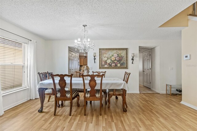 10311 Frog Pond Dr, Riverview, FL 33569 - dining room with a chandelier, light wood-style floors, a textured ceiling, and baseboards