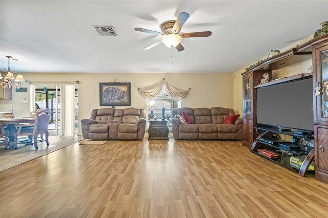 10311 Frog Pond Dr, Riverview, FL 33569 - living room with light wood-style flooring, a ceiling fan, plenty of natural light, and a chandelier