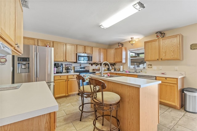 10311 Frog Pond Dr, Riverview, FL 33569 - kitchen featuring stainless steel appliances, a sink, an island with sink, a breakfast bar, and light countertops