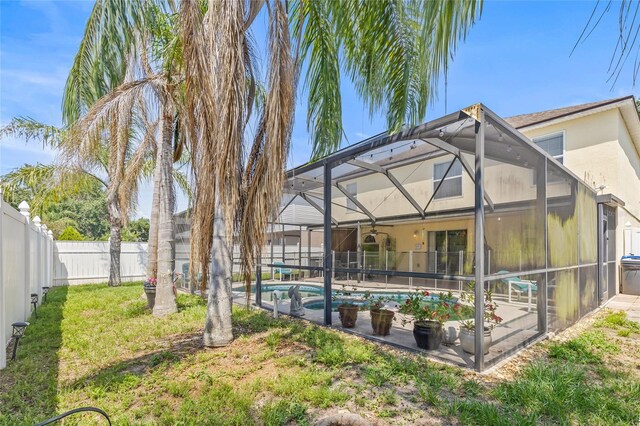 10311 Frog Pond Dr, Riverview, FL 33569 - back of house with a fenced backyard, glass enclosure, stucco siding, and a patio