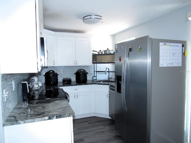 8996 Southern Comfort Dr, Largo, FL 33773 - kitchen with appliances with stainless steel finishes, a sink, tasteful backsplash, white cabinetry, and dark wood-type flooring