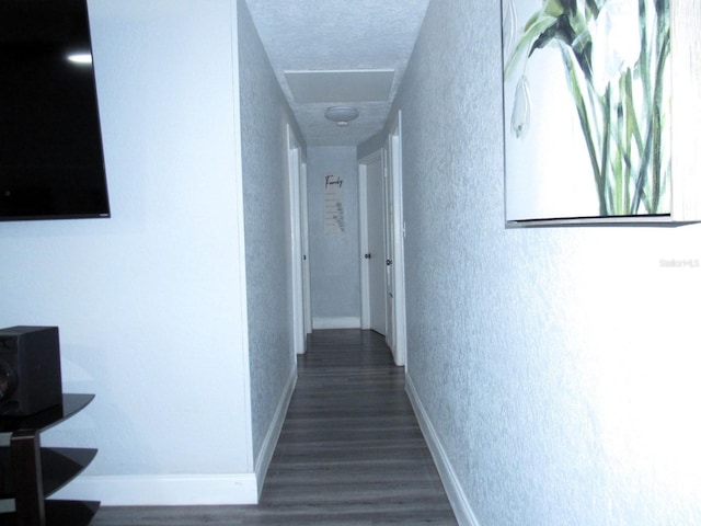 8996 Southern Comfort Dr, Largo, FL 33773 - hall with a textured wall, wood finished floors, baseboards, and attic access