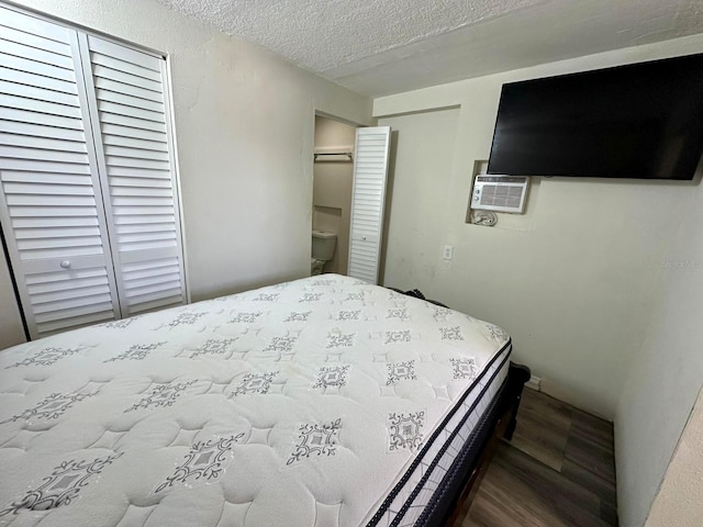 8996 Southern Comfort Dr, Largo, FL 33773 - bedroom featuring wood finished floors, a textured ceiling, and a wall mounted air conditioner