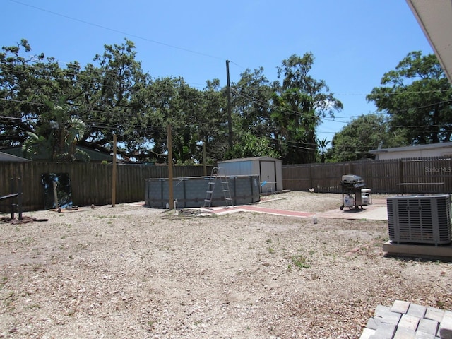 8996 Southern Comfort Dr, Largo, FL 33773 - fenced backyard with central air condition unit, a storage unit, a patio, and an outdoor structure