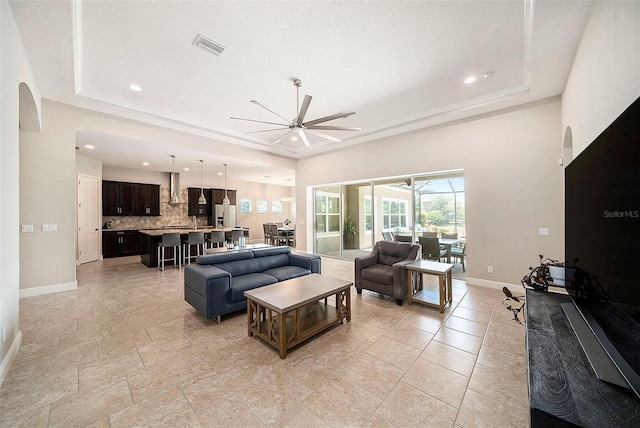 8016 Rock Spring Ct, Land O Lakes, FL 34638 - living room with a ceiling fan, a raised ceiling, arched walkways, and recessed lighting
