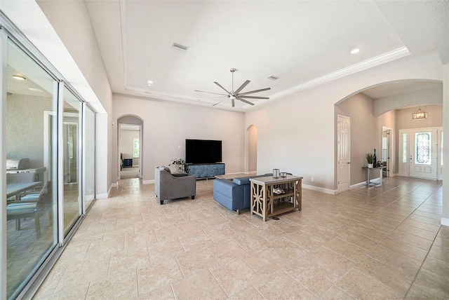 8016 Rock Spring Ct, Land O Lakes, FL 34638 - living room with arched walkways, stone tile floors, a ceiling fan, recessed lighting, and a raised ceiling