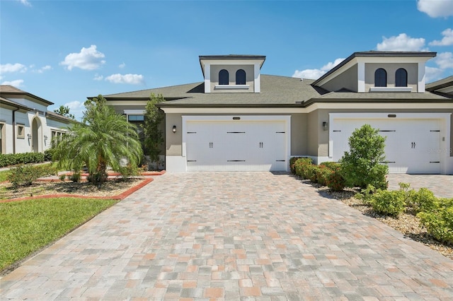 4325 Barletta Ct, Wesley Chapel, FL 33543 - view of front facade with stucco siding, decorative driveway, a shingled roof, and a garage