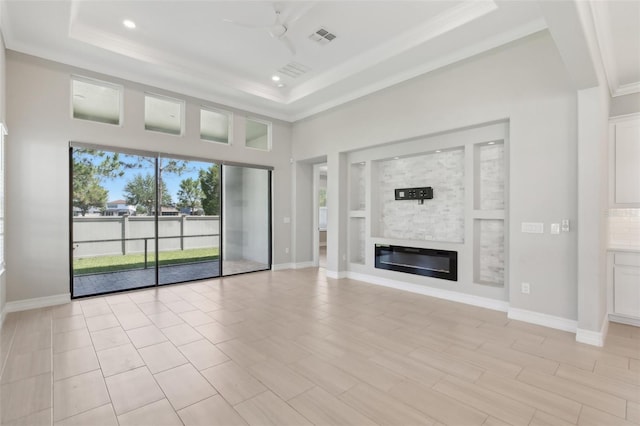 4325 Barletta Ct, Wesley Chapel, FL 33543 - unfurnished living room with a raised ceiling, crown molding, a glass covered fireplace, ceiling fan, and recessed lighting