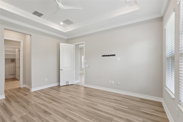 4325 Barletta Ct, Wesley Chapel, FL 33543 - unfurnished bedroom with a tray ceiling, crown molding, light wood finished floors, and baseboards