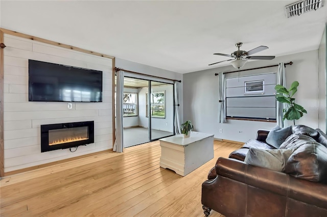 550 George St S, Tarpon Springs, FL 34688 - living area with a fireplace, light wood-style floors, ceiling fan, and baseboards
