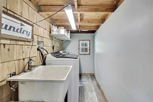 550 George St S, Tarpon Springs, FL 34688 - laundry area with washing machine and dryer, light wood-type flooring, and baseboards