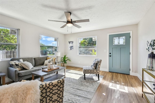 1750 Dayton St S, Saint Petersburg, FL 33712 - living area featuring a ceiling fan, a textured ceiling, baseboards, and wood finished floors