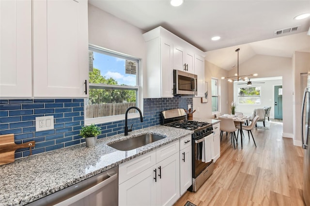 1750 Dayton St S, Saint Petersburg, FL 33712 - kitchen featuring appliances with stainless steel finishes, a sink, healthy amount of natural light, light wood finished floors, and lofted ceiling