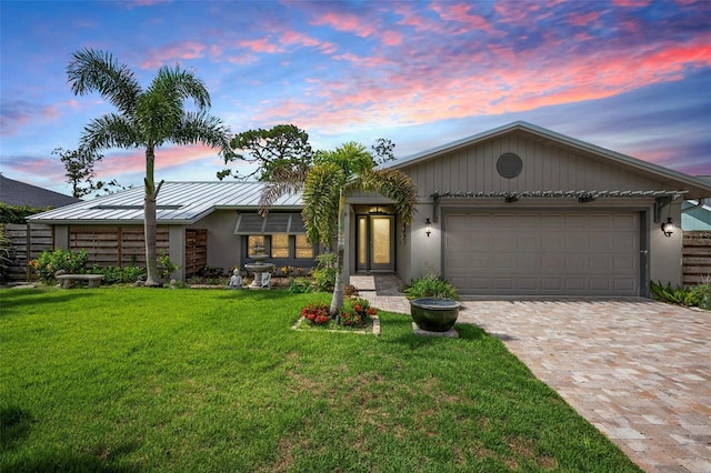 2320 James Ln, Sarasota, FL 34231 - view of front of property featuring a standing seam roof, decorative driveway, a garage, a lawn, and a metal roof