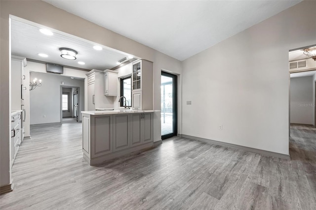 2320 James Ln, Sarasota, FL 34231 - kitchen featuring light wood-style flooring, light countertops, a peninsula, gray cabinetry, and recessed lighting