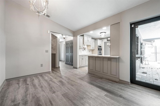 2320 James Ln, Sarasota, FL 34231 - unfurnished living room featuring light wood-style flooring, a chandelier, and lofted ceiling