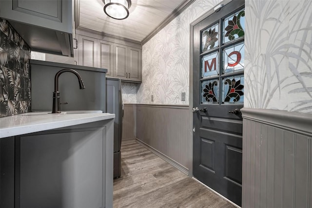 2320 James Ln, Sarasota, FL 34231 - laundry room with wallpapered walls, wainscoting, light wood-style floors, and ornamental molding