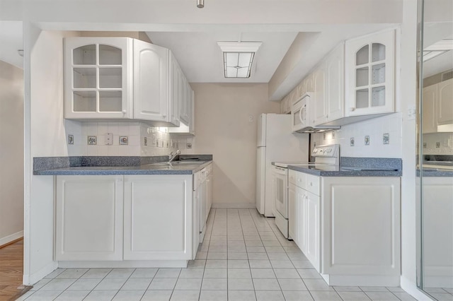 10355 Paradise Blvd Unit 502, Treasure Island, FL 33706 - kitchen with white appliances, decorative backsplash, glass insert cabinets, and a sink