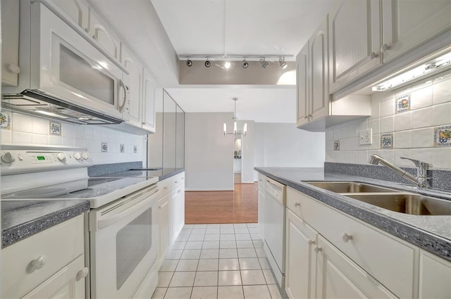 10355 Paradise Blvd Unit 502, Treasure Island, FL 33706 - kitchen featuring white appliances, a sink, rail lighting, and dark countertops