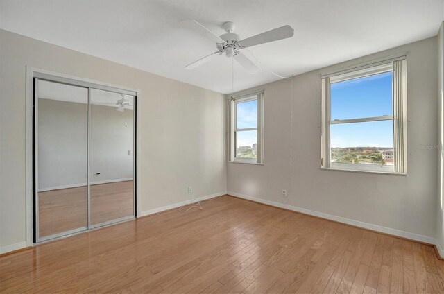 10355 Paradise Blvd Unit 502, Treasure Island, FL 33706 - unfurnished bedroom with light wood finished floors, baseboards, a closet, and a ceiling fan