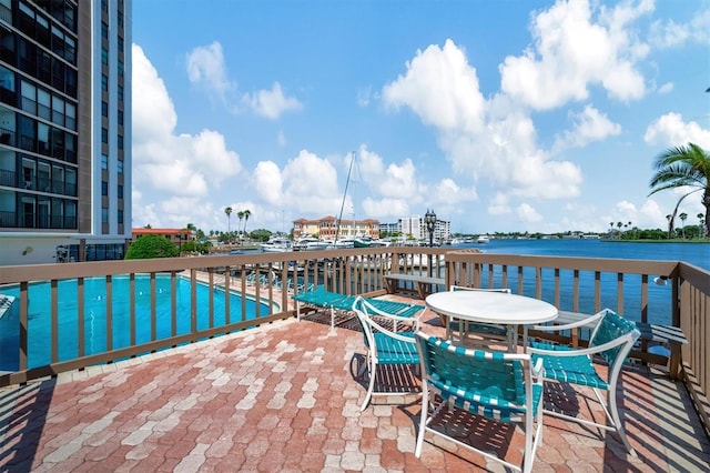 10355 Paradise Blvd Unit 502, Treasure Island, FL 33706 - community pool with a water view, a patio area, and outdoor dining area