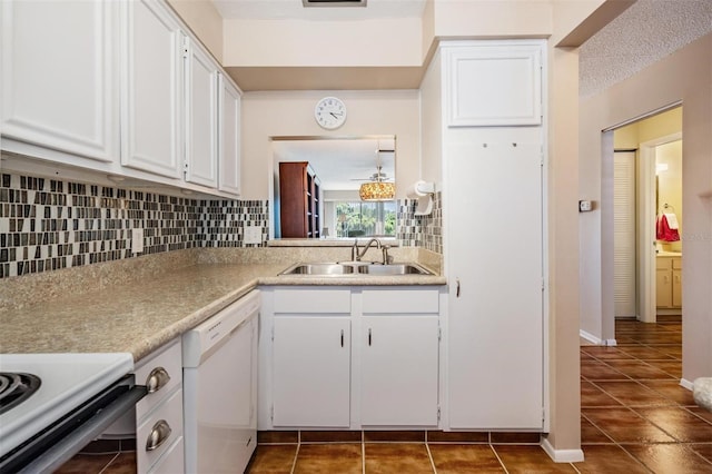 3839 Trophy Blvd Unit 3839, New Port Richey, FL 34655 - kitchen featuring a sink, white dishwasher, dark tile patterned floors, backsplash, and white cabinets