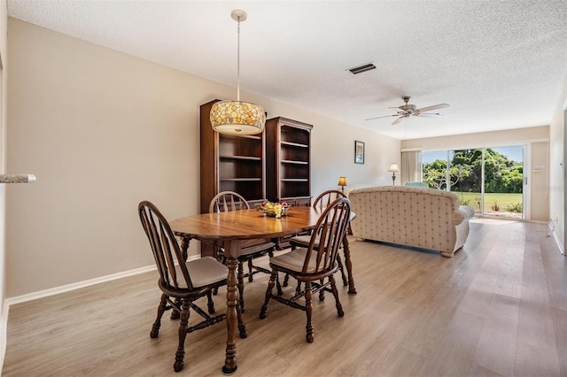 3839 Trophy Blvd Unit 3839, New Port Richey, FL 34655 - dining area featuring ceiling fan, light wood-style floors, a textured ceiling, and baseboards