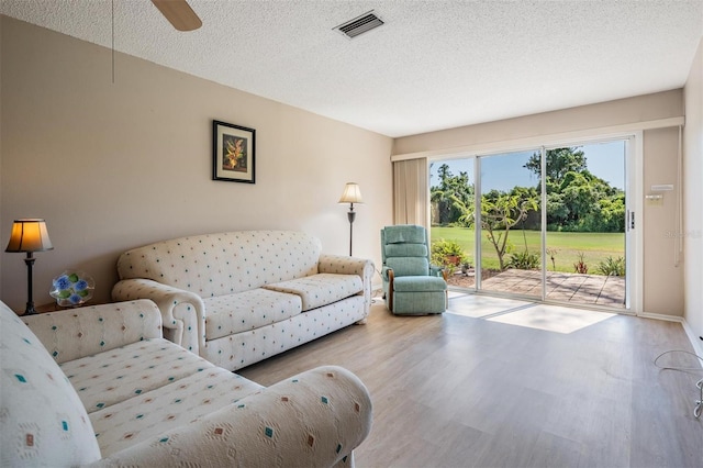 3839 Trophy Blvd Unit 3839, New Port Richey, FL 34655 - living area featuring wood finished floors, a textured ceiling, ceiling fan, and baseboards