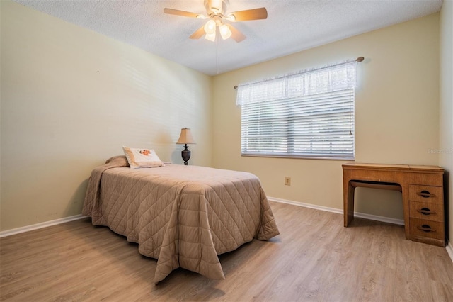 3839 Trophy Blvd Unit 3839, New Port Richey, FL 34655 - bedroom with light wood finished floors, baseboards, a textured ceiling, and a ceiling fan
