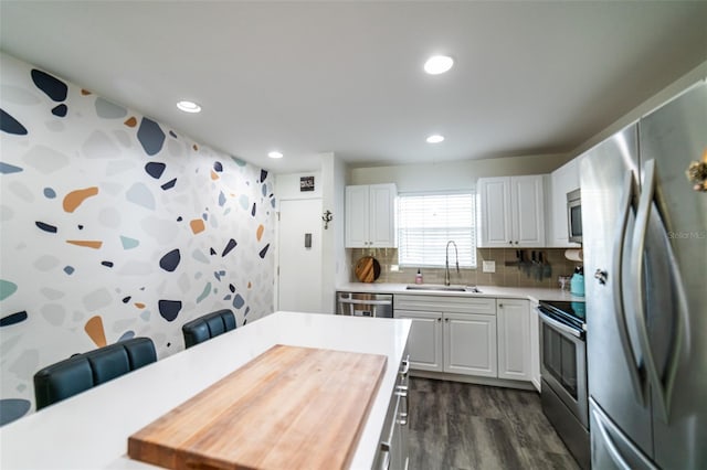 3850 13th Ave N Unit 113, Saint Petersburg, FL 33713 - kitchen featuring stainless steel appliances, a sink, dark wood-type flooring, recessed lighting, and white cabinets