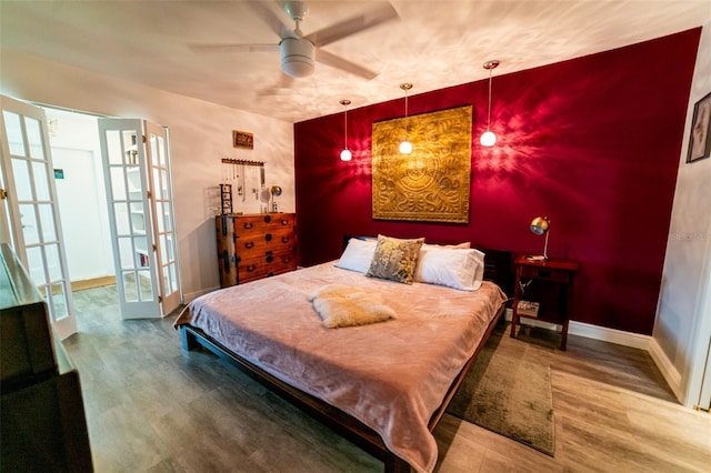 3850 13th Ave N Unit 113, Saint Petersburg, FL 33713 - bedroom featuring wood finished floors, an accent wall, french doors, and baseboards