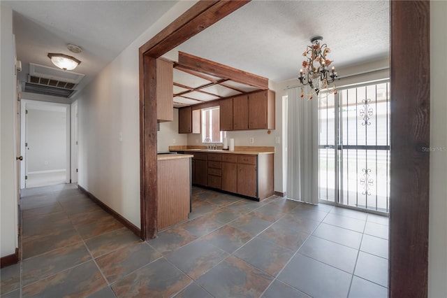 2614 E Liberty St, Tampa, FL 33612 - kitchen with plenty of natural light, light countertops, and a chandelier