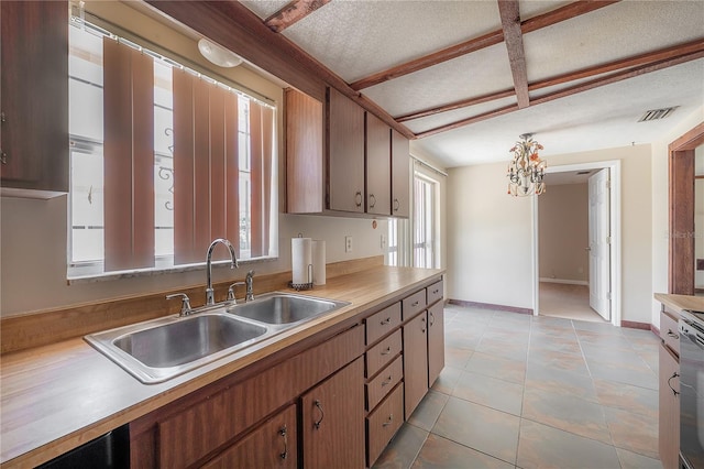 2614 E Liberty St, Tampa, FL 33612 - kitchen featuring light countertops, a textured ceiling, light tile patterned floors, a chandelier, and range