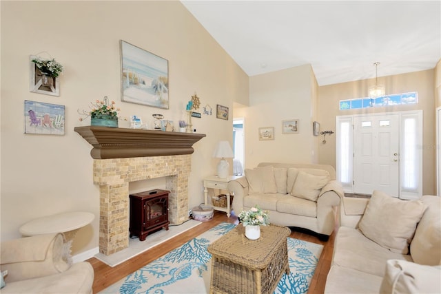 11148 Hollander Ave, Hudson, FL 34667 - living area featuring wood finished floors, high vaulted ceiling, a wood stove, and a chandelier