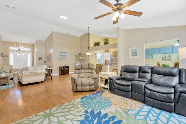 11148 Hollander Ave, Hudson, FL 34667 - living room featuring ceiling fan, light wood finished floors, a chandelier, high vaulted ceiling, and baseboards